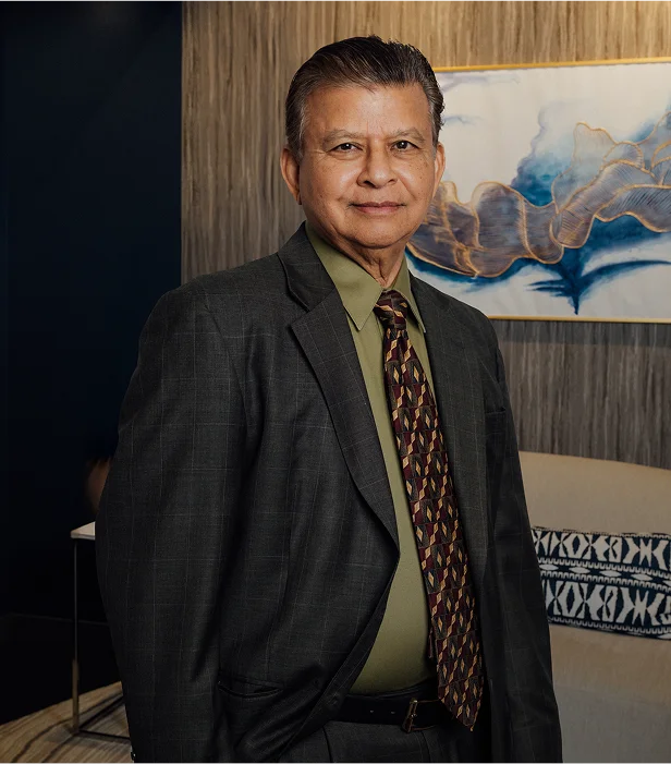 Portrait of Dr. Rajendra Shah in a grey suit.